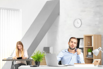 Young man suffering from heat in office