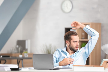 Young man sweating in office