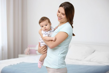 Young mother with her cute little baby at home