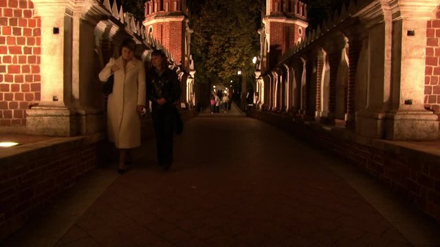 People are walking on bridge Tsaritsyno Museum in Moscow at night. Beautiful views of capital of Russia.