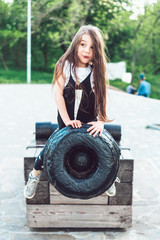 Fototapeta na wymiar preschool girl sitting on top of a cannon