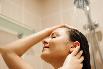 Naklejka premium Woman with long hair taking shower.