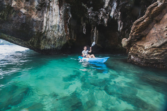 kayaker paddling in crystal clear water near the cave on Railay beach in Krabi, tourist travel on kayak in Thailand, blurred motion
