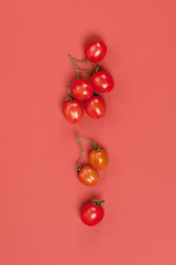 Ripe cherry tomatoes on a pastel red background close-up..