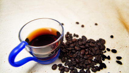 soft focus of a cup of energetic drink infusion and coffee beans with a raw background. for detox and healthy concept