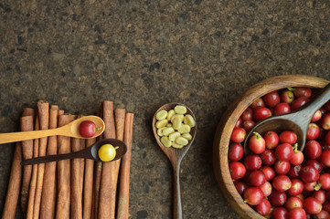 fresh coffee beans in wooden bowl with cinnamon for background