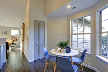 Lovely breakfast nook with white round table and blue chairs.