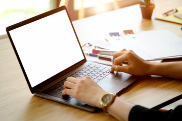 Cropped shot of an unrecognizable woman working on her laptop at home.