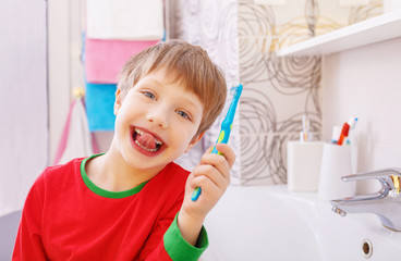 Little funny boy with a funny expression on his face in the bathroom