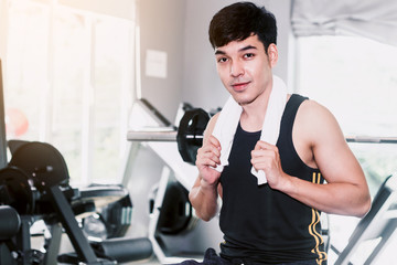 Obraz na płótnie Canvas Handsome sports man standing with towel at the gym