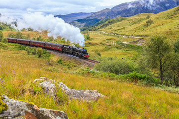 Aufnahme eines Personenzuges mit Dampflokomotive auf der Fahrt durch die schottischen Highlands fotografiert tagsüber im September 2014