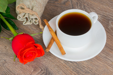 red rose with coffee cup on wooden table