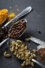 Obraz premium Various spices spoons on stone table.On dark concrete background.Herbs and spices on wooden table.