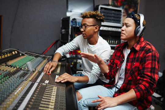Young producer and singer sitting in studio of records and doing their work
