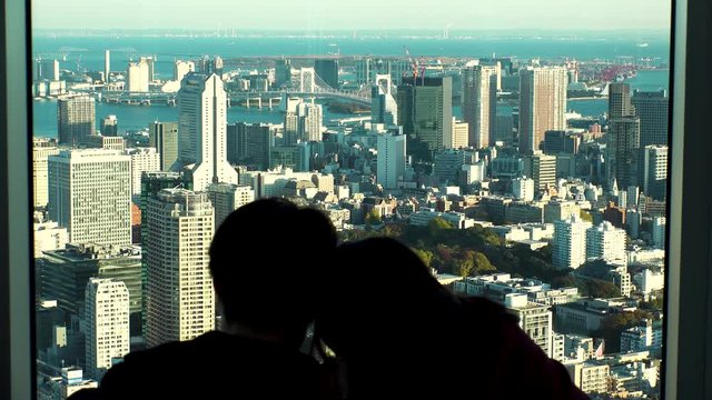 Japan Tokyo man and woman watching cityscape of Tokyo from above. Romantic couple concept.