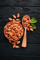 Almond nuts on a dark wooden background. Healthy snacks. Top view. Free space for text.