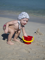 hands of little girl play with sand on beach