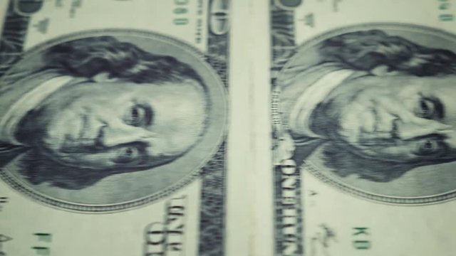 close-up portrait of Benjamin Franklin on the banknote 100 us dollar conveyor movement from the left to the right side with a stop