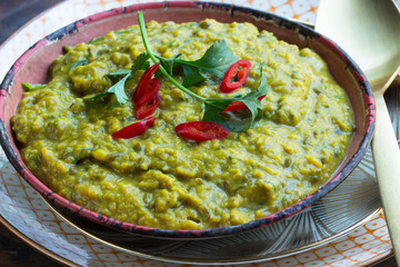 Veganer Dhal, indisches Linsengericht in einer Schüssel mit Petersilie angerichtet
