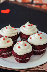 Red velvet cupcakes with cream cheese frosting on a white plate