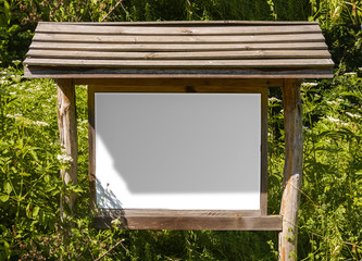 A blank white board in a forest for information ,sign for advertising with shadows.