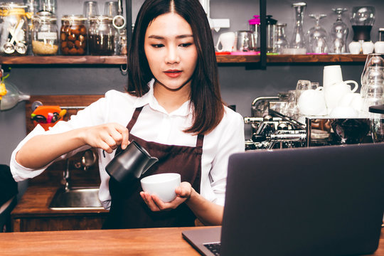 Barista holding milk for make coffee latte art in coffee shop