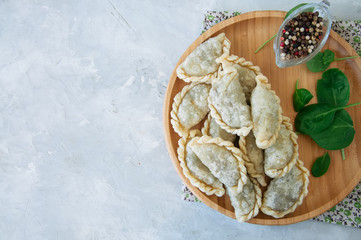 Fried savory pasties - hand pies with spinach on a white background. Top view and copy space.