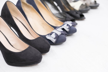Different woman's shoes on wooden floor