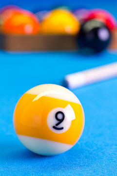 Billiard pool game nine ball with cue on billiard table