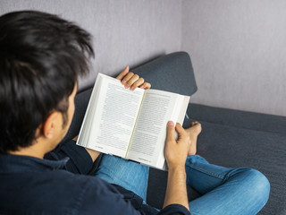 Man reading book on sof