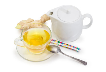 Tea with ginger slices in glass cup and ginger root