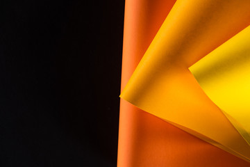 orange and yellow papers isolated on black