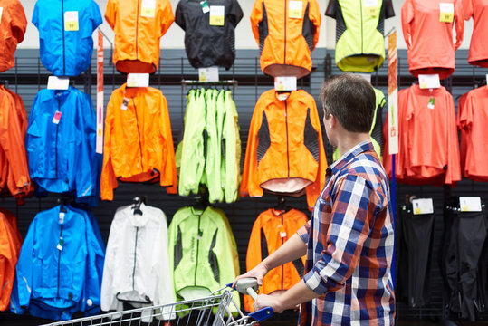 Man chooses sports clothes in store