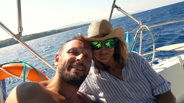 Happy couple taking selfie photos while sailing boat on ocean, super slow motion 240fps
