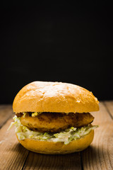 Burger on the black wooden background. Selective focus.