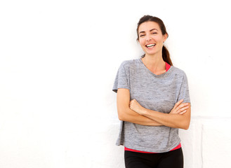 Fototapeta premium attractive young sports woman smiling with arms crossed against white wall