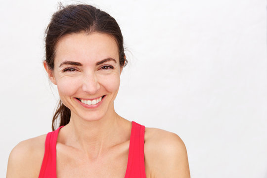 Close up cheerful young sports woman smiling over white background