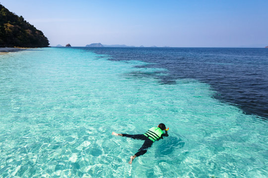Woman snorkeling in crystal clear water, Andaman sea