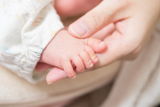 赤ちゃんの足と母親の手
