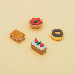 cookie, cakes and donut on yellow background. sweet food. minimal flat lay. dessert concept of miniatures