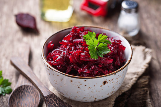Bowl of beetroot salad on wooden background