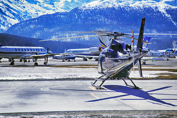 Private jets, planes and helicopters in the airport of St Moritz Switzerland in the alps © CoolimagesCo
