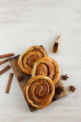 Cinnamon rolls, decorated with spices, on a light background