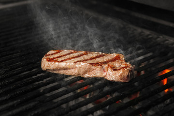 Beef steak medium roast cooking on grill, preparing meat