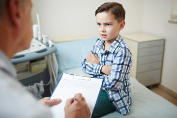 Little boy talking to clinician while discussing prescriptions or symptoms