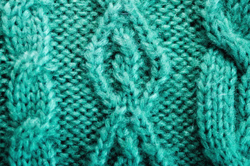 Knitted texture. Pattern fabric made of wool. Turquoise background, copy space