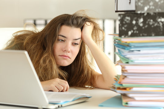 Tired and bored intern looking at paperwork