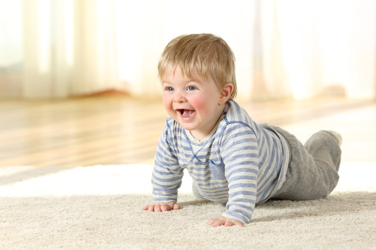 Happy baby crawling on a carpet at home