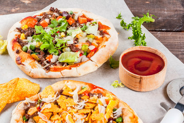Homemade Mexican Taco PIzza with Nachos  chips, beans, fresh vegetables, beef meat, copy space