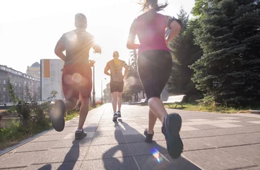 Abwaschbare Fototapete Joggen Gruppe junger Leute, die in der Stadt joggen